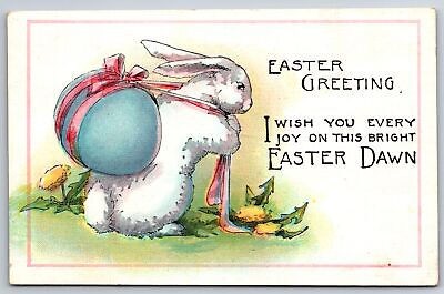 #ad Easter White Bunny Rabbit Toils With Big Blue Egg On Back Dandelions 1915 PC $10.00